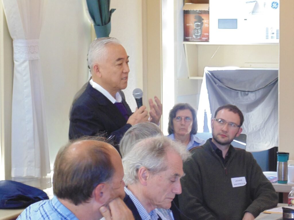 A gentleman speaks before a crowd at the Dungeness Schoolhouse Conference